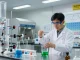 Scientist demonstrating synthesis grade chemicals in a vibrant lab setting with chemical reactions.